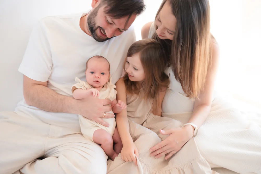 Eltern und Geschwisterkind mit ihrem Baby.